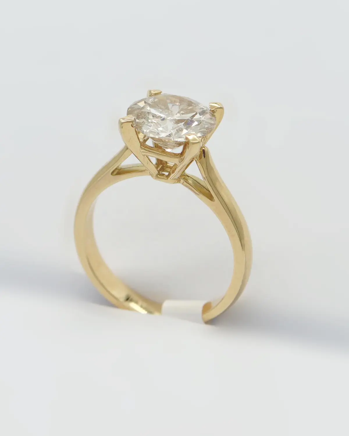 Gold solitaire diamond ring from Diamantea on a light background