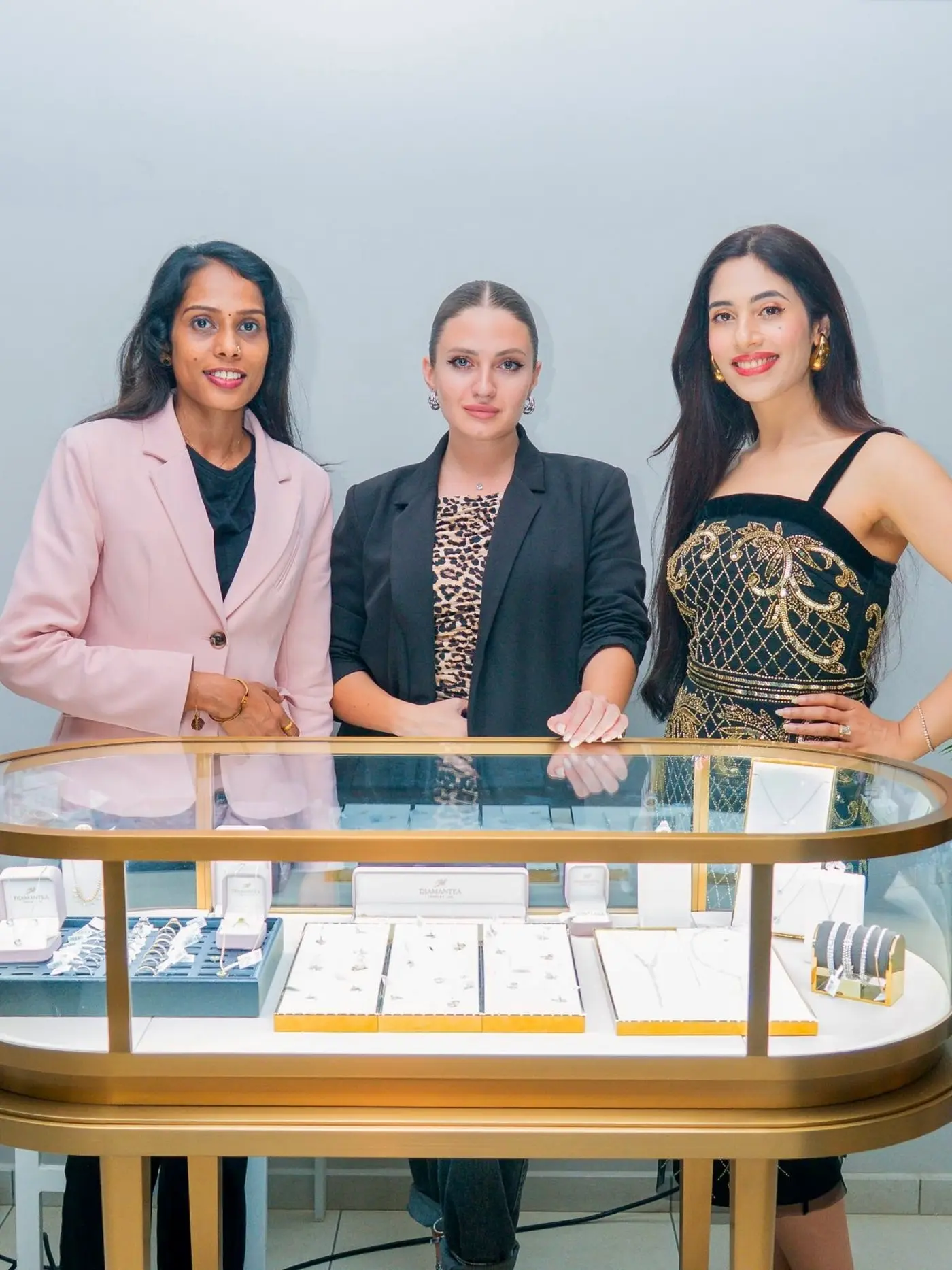 Diamantea team members standing behind a jewelry display counter